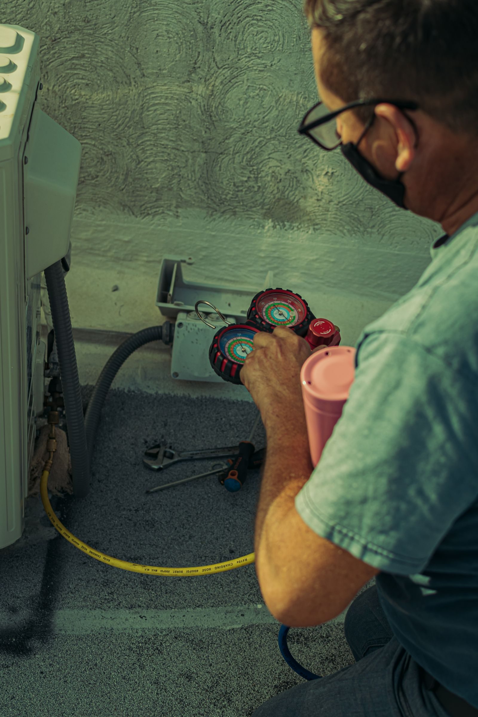 Technician using manifold gauges on a service call